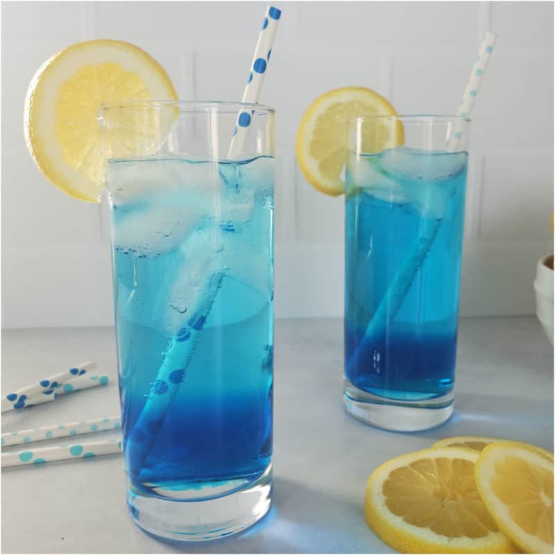 2 blue cocktails with lemon wheels and paper straws