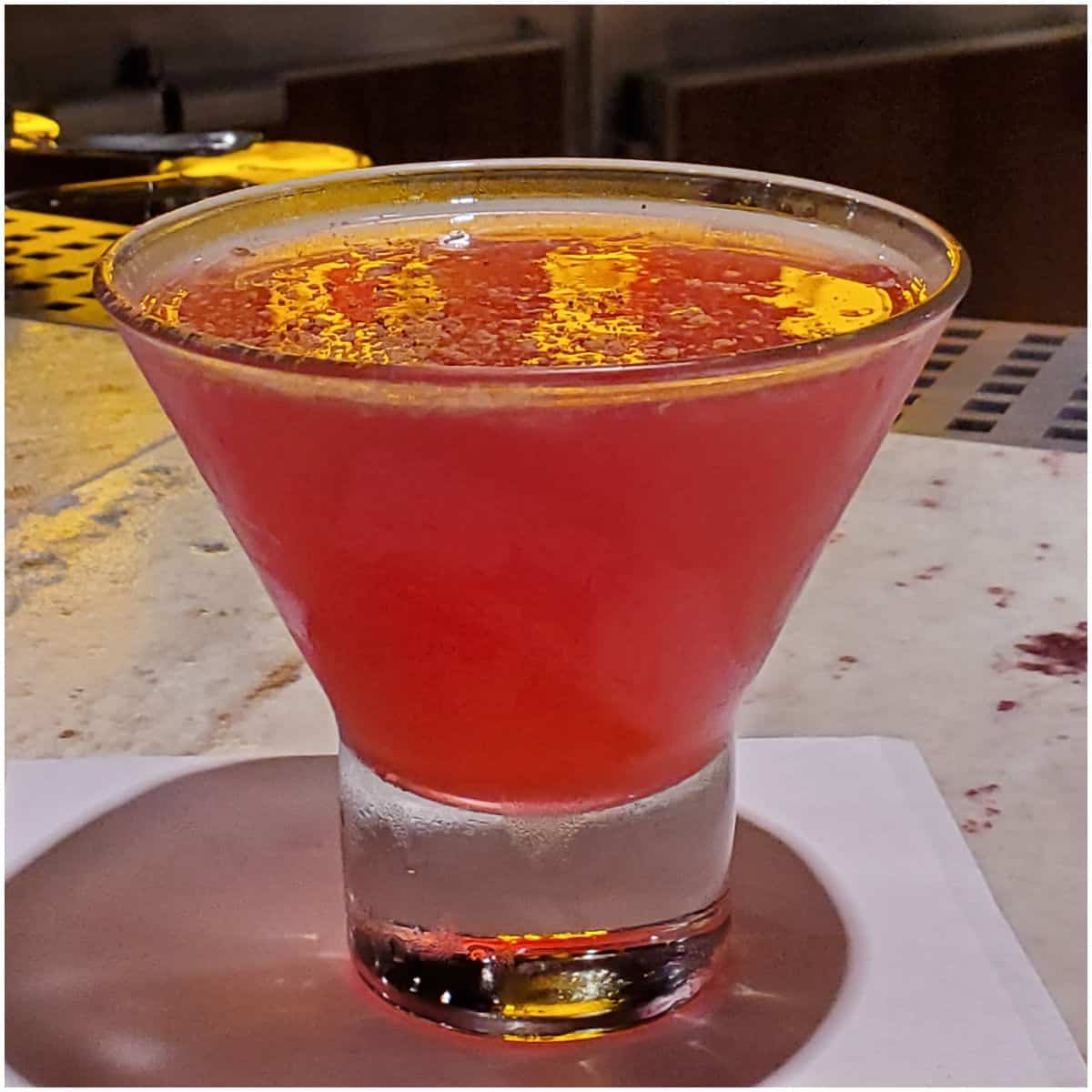 red martini in a stemless martini glass on a white napkin