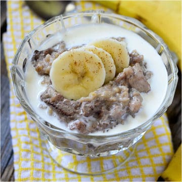 Banana Bread oatmeal with banana slices in a glass bowl on a yellow napkin