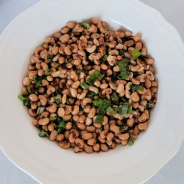 Black Eyed Pea Salad in a white bowl garnished with green onions