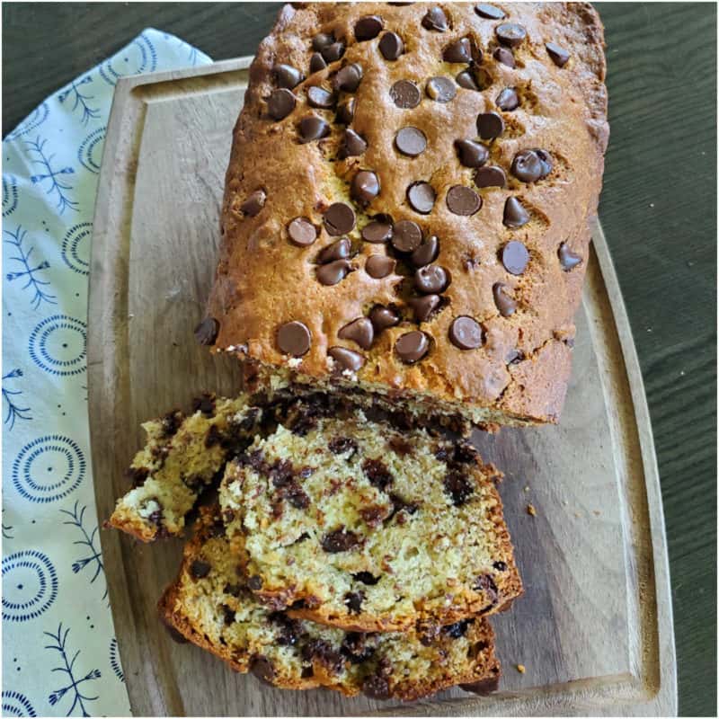 Chocolate Chip Banana Bread on a wooden board next to a cloth napkin