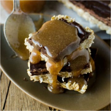 chocolate oatmeal bars stacked with caramel dripping on the top