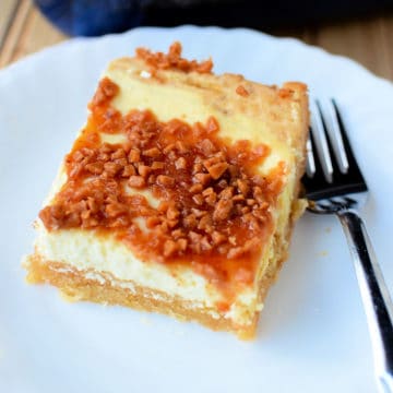 Creme brulee cheesecake bar on a white plate next to a fork