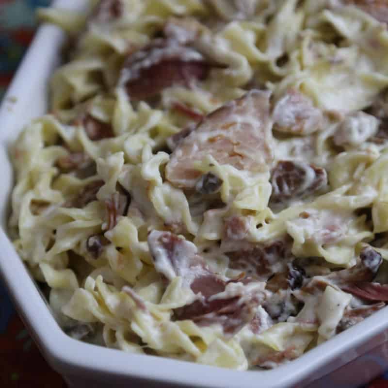 ham and swiss cheese pasta in a white casserole dish