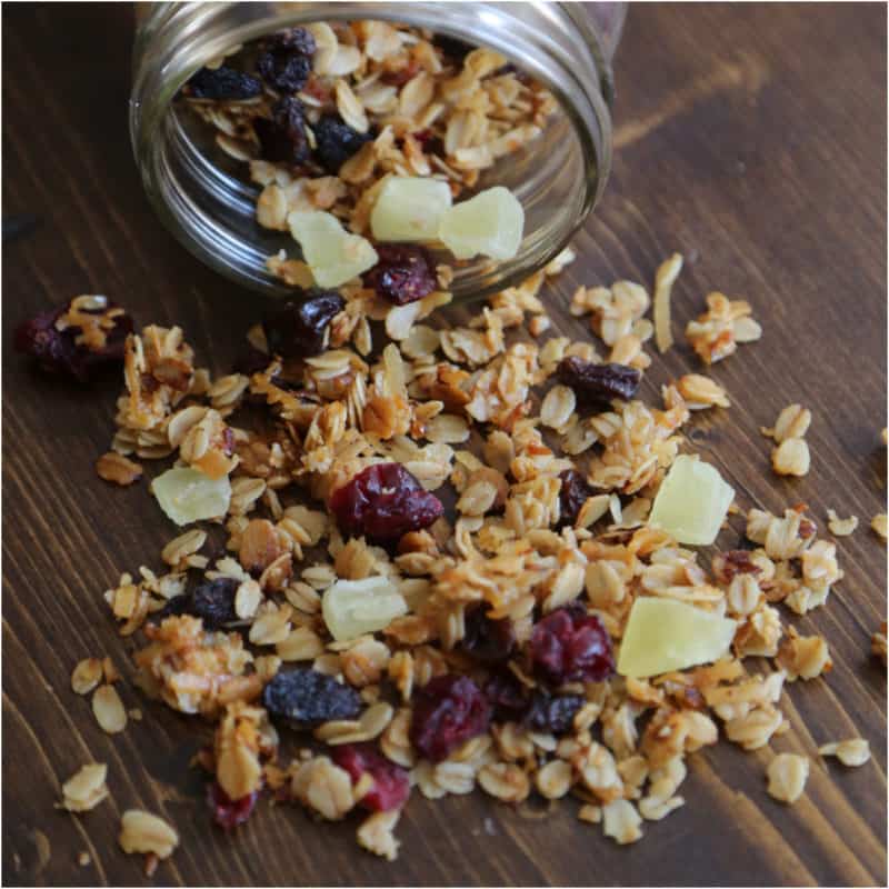 Crockpot granola with dried fruit pouring out of a mason jar