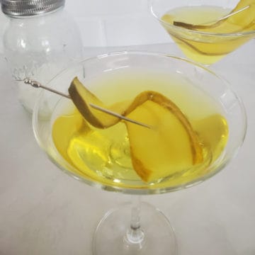 Pickle martini in a martini glass with pickle garnish