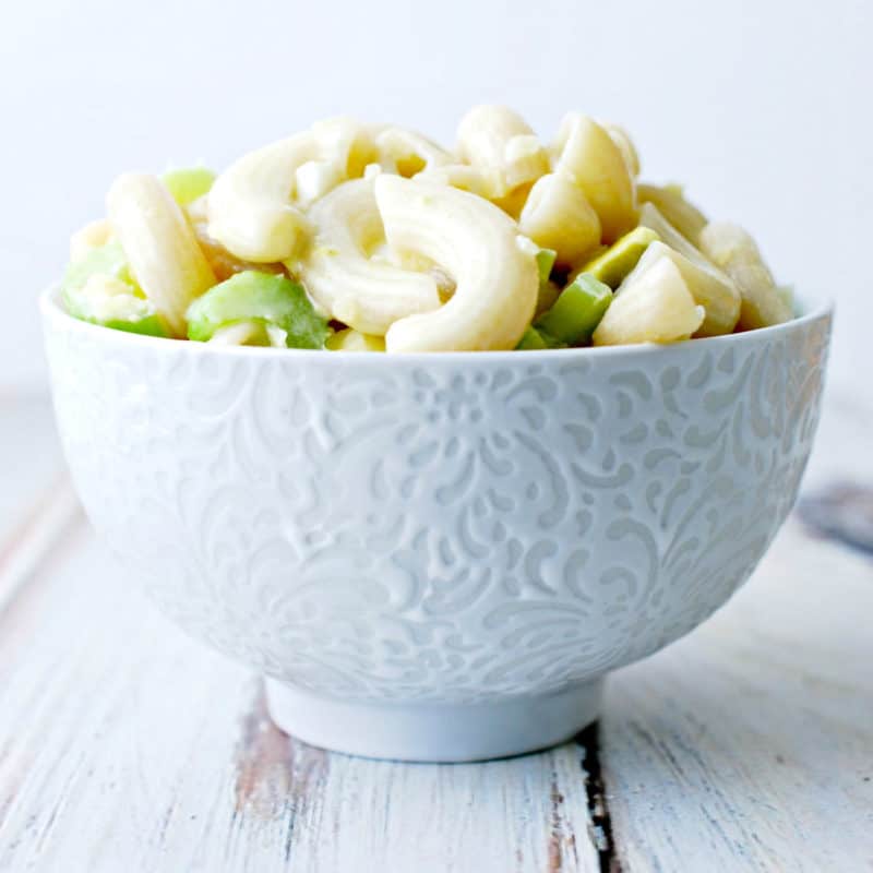 Macaroni salad and celery in a white bowl