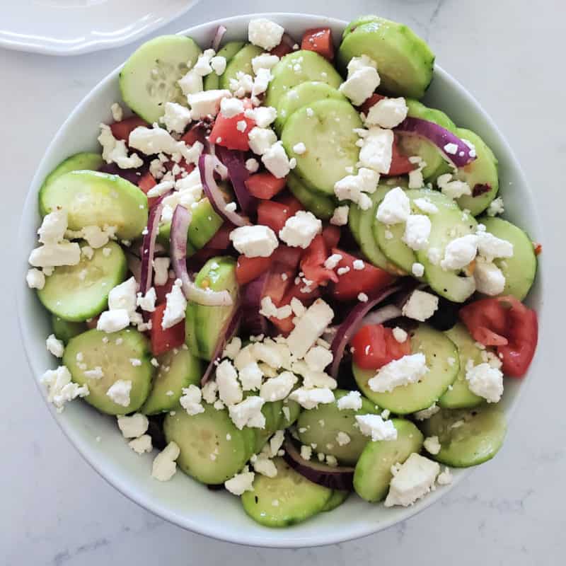 Greek Cucumber Salad with Feta in a white bowl 