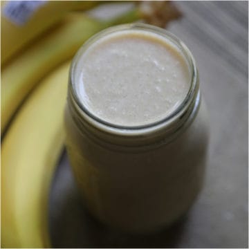 Peanut Butter Banana Smoothie in a mason jar next to bananas