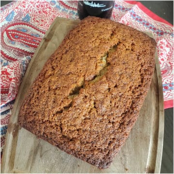 port wine banana bread on a wooden cutting board next to a napkin