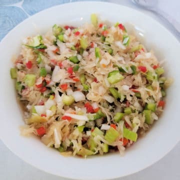 Sauerkraut Salad in a white bowl next to a fork