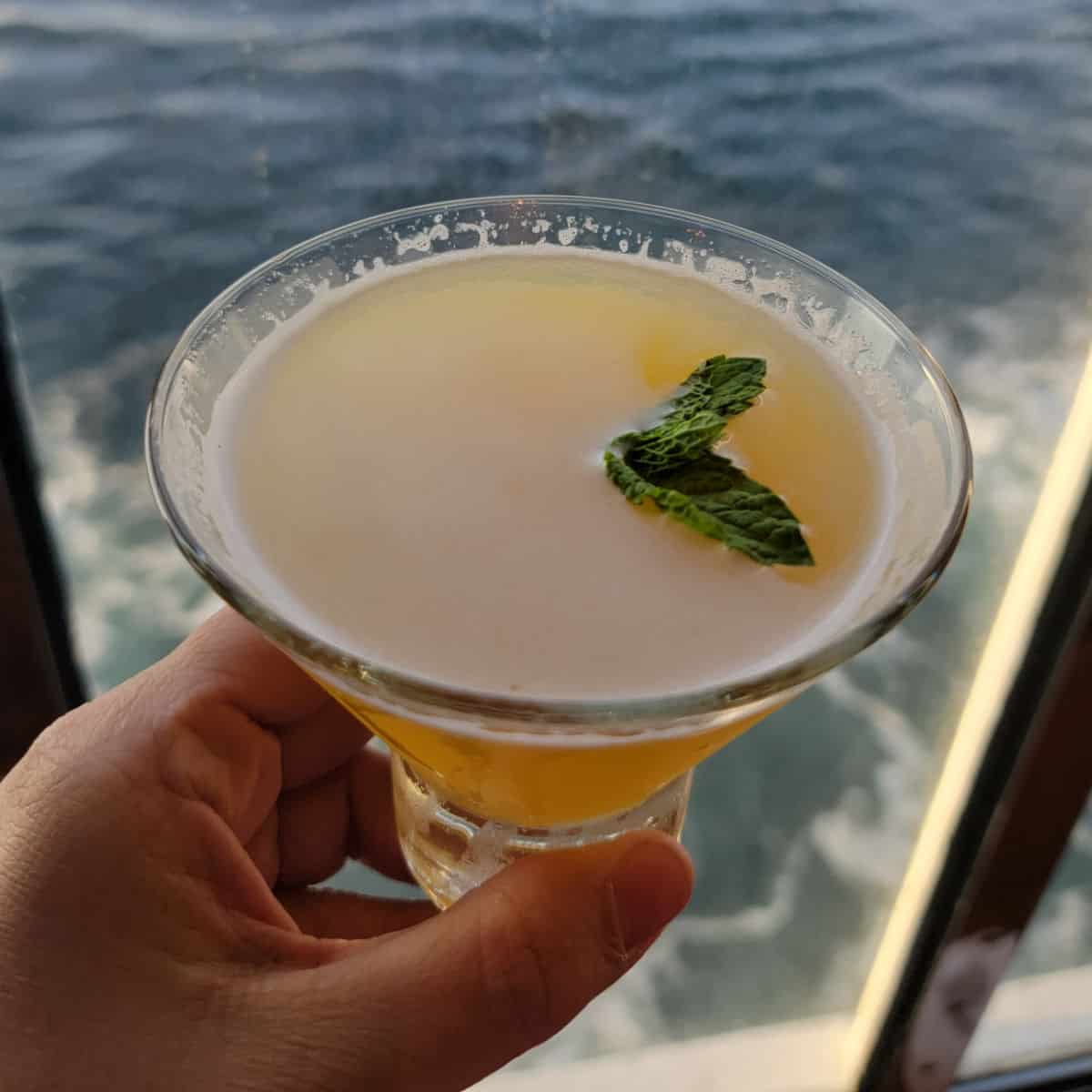 Spicy Chipotle martini in a stemless martini glass with ocean water in the background