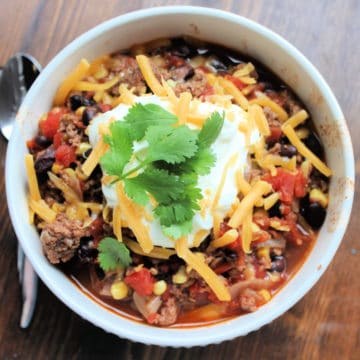 Taco soup garnished with cilantro in a white bowl