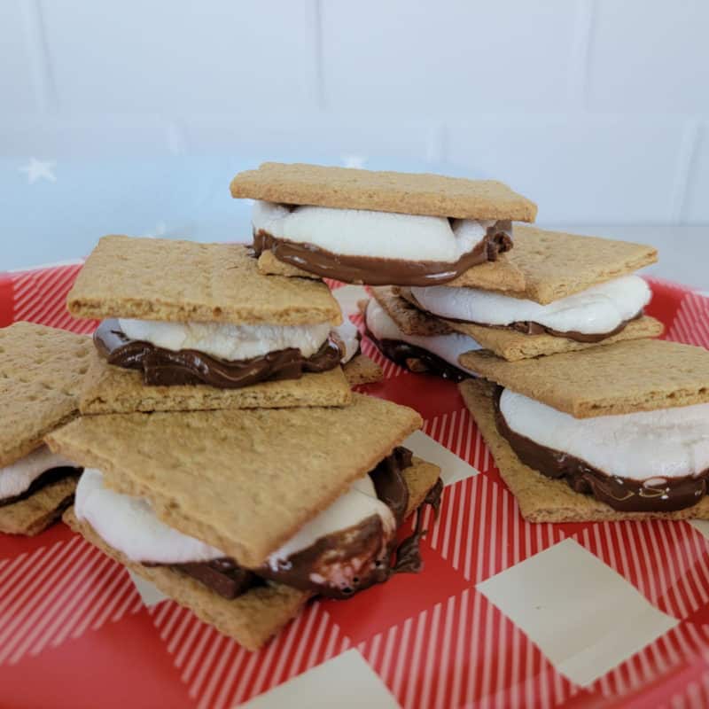 Stack of smores made in the oven on a red checked plate