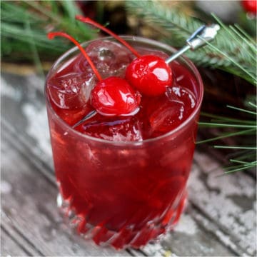 Mulled Cherry Cider in a short glass with maraschino cherry garnish