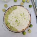 No bake key lime pie garnished with lime slices next to key limes