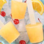 screwdriver popsicles on a bed of ice with maraschino cherries