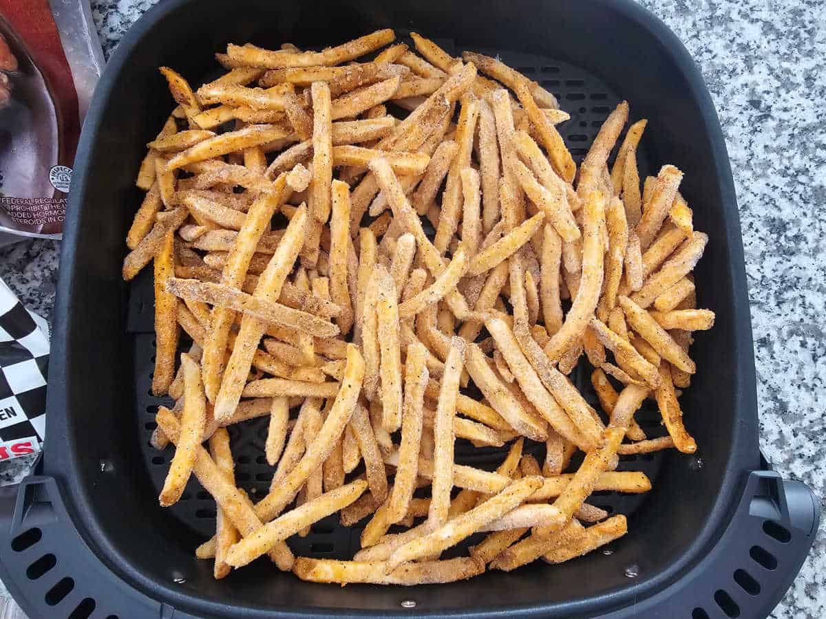 Frozen checkers french fries in an air fryer basket