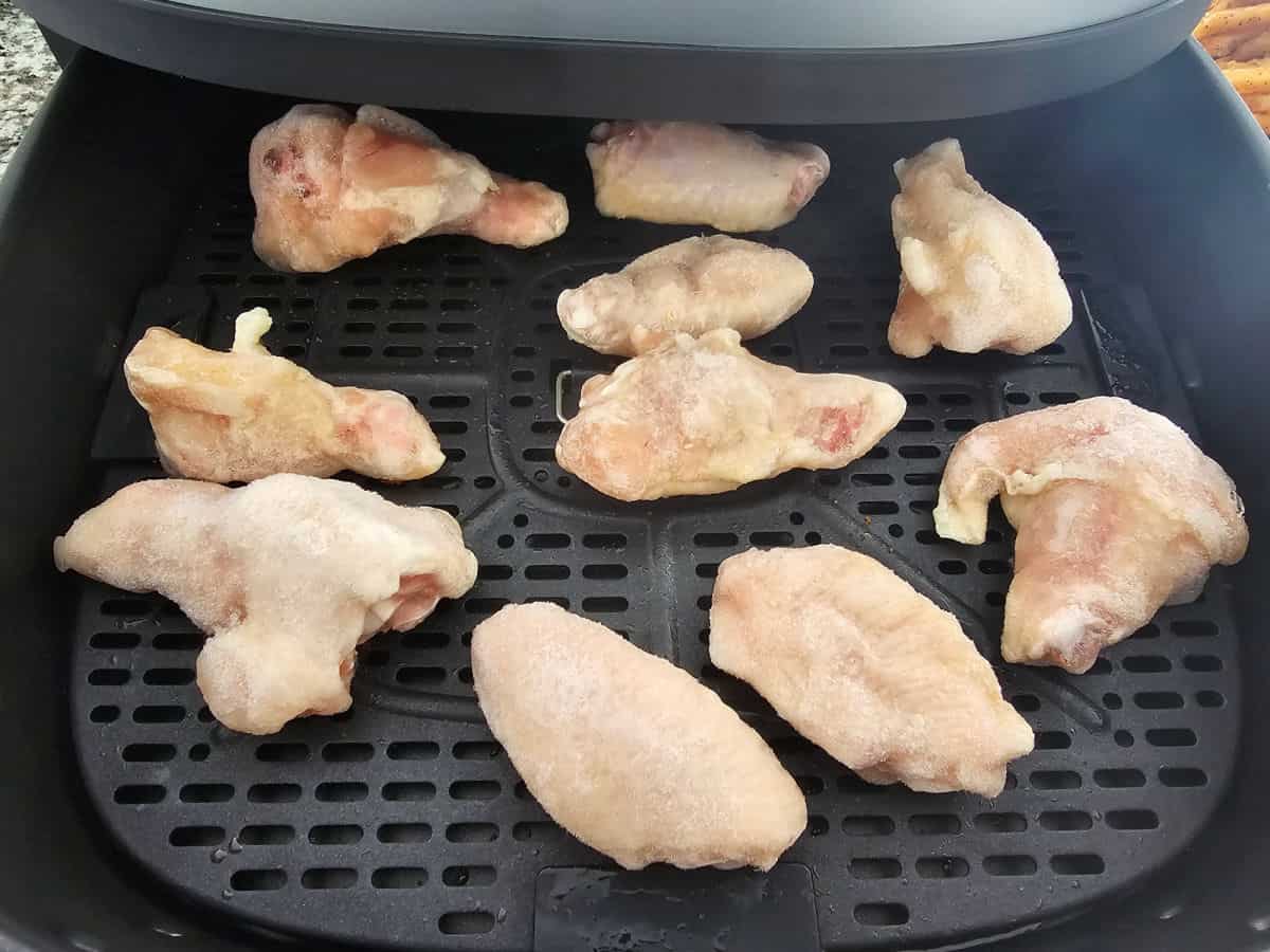 frozen chicken wings in an air fryer basket