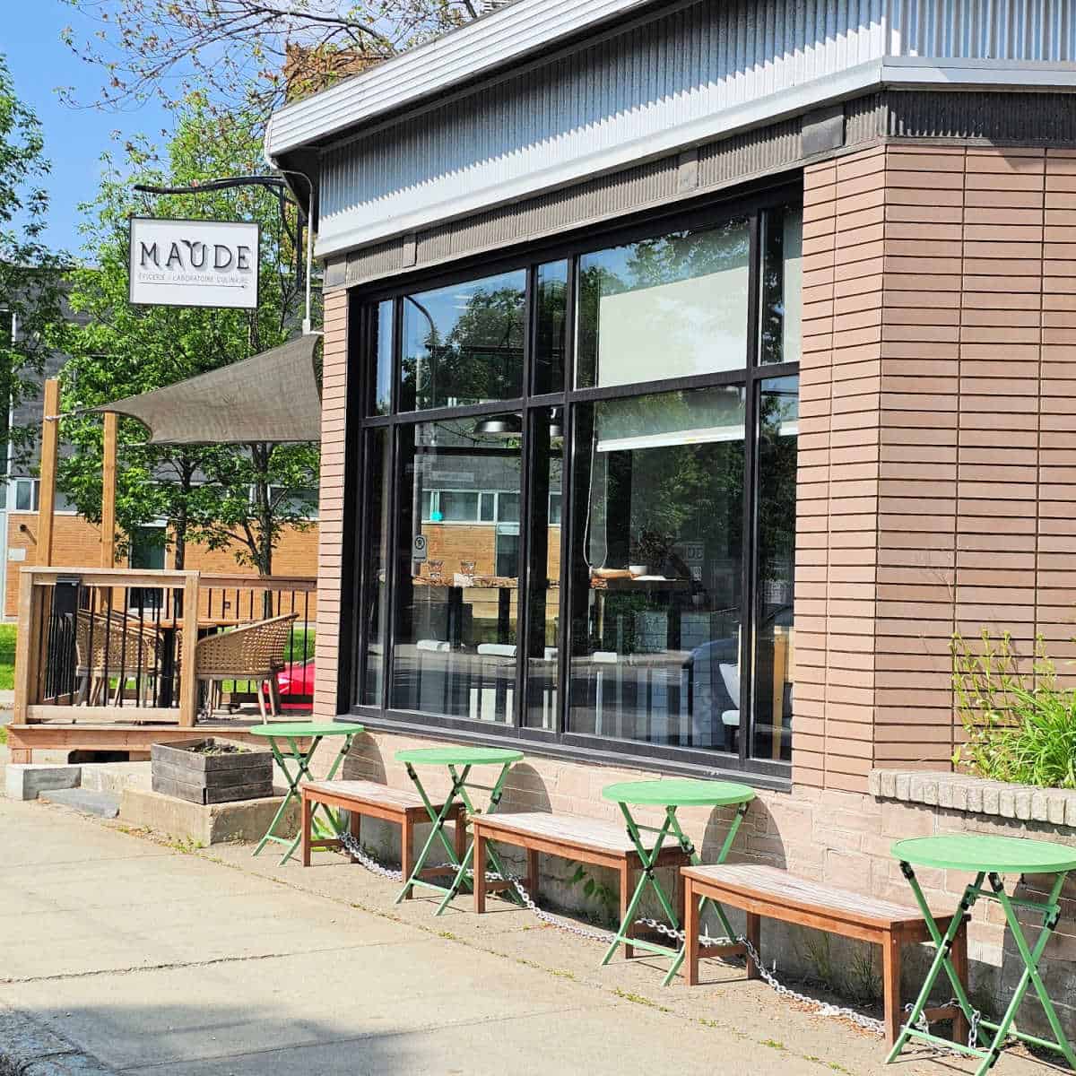 Maude sign over the entrance to the restaurant and store with tables and benches outside