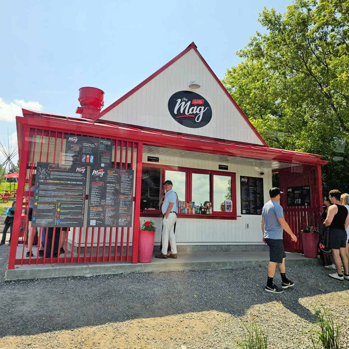 Chez Mag red and white food stand with people lined up