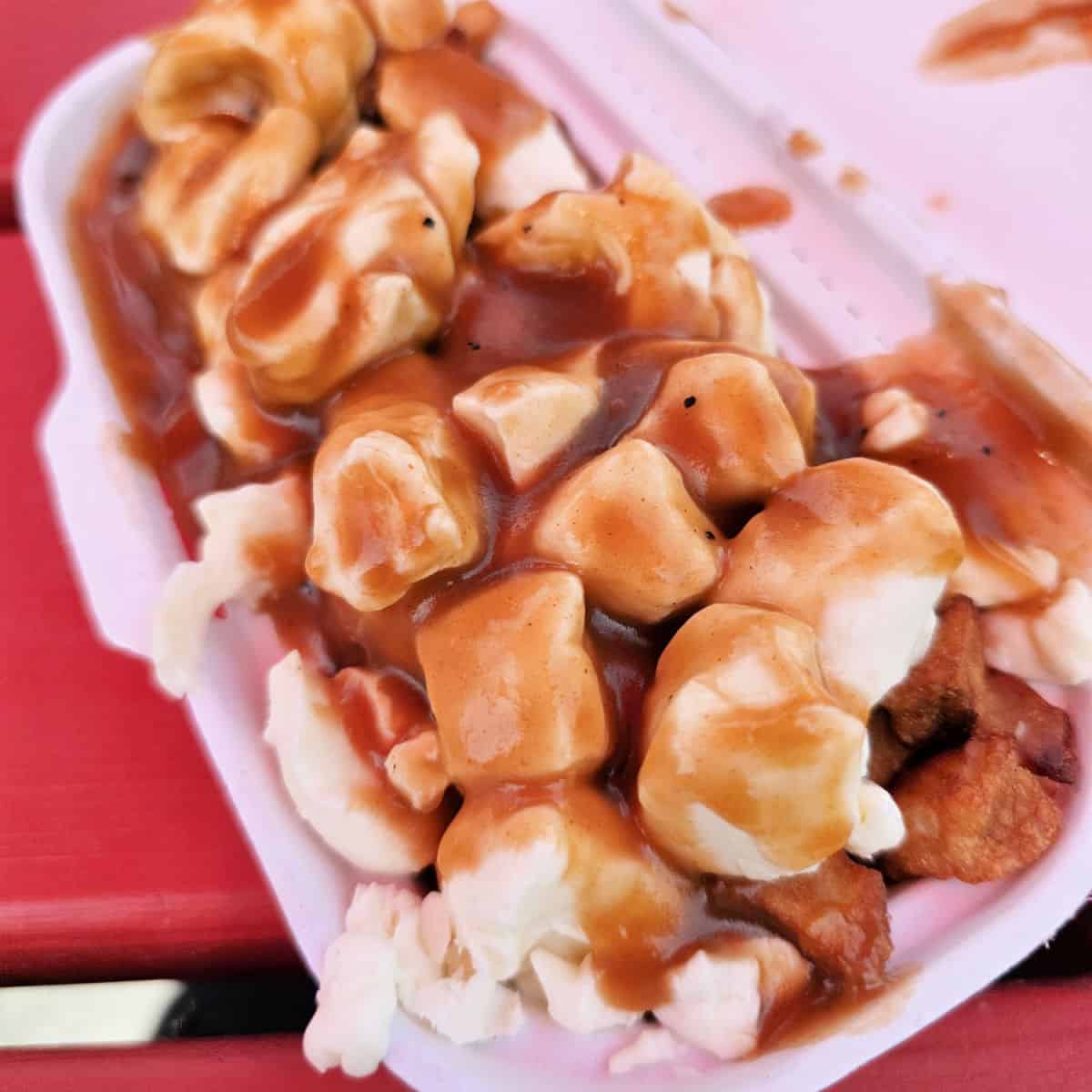 Cheese curds in a container on a red table