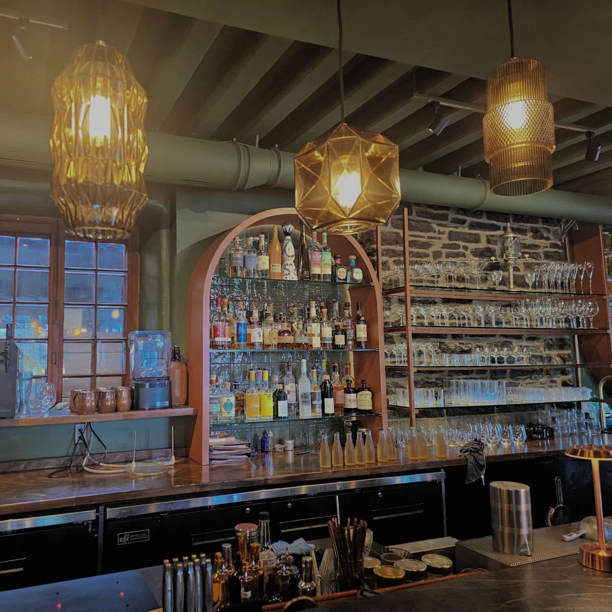cocktail bar with shelves of liquor, glassware and bottles