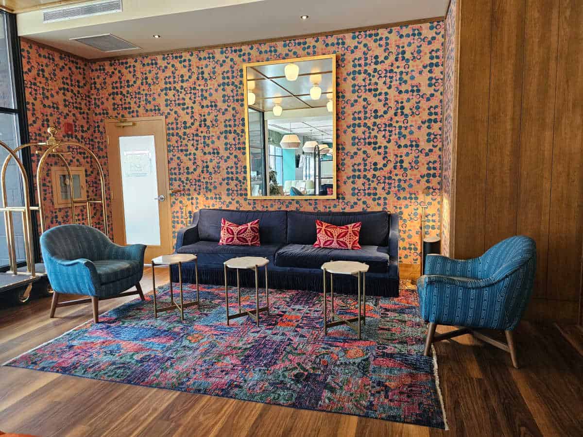 colorful lobby sitting area with blue couch, blue chairs, and brightly colored wallpaper