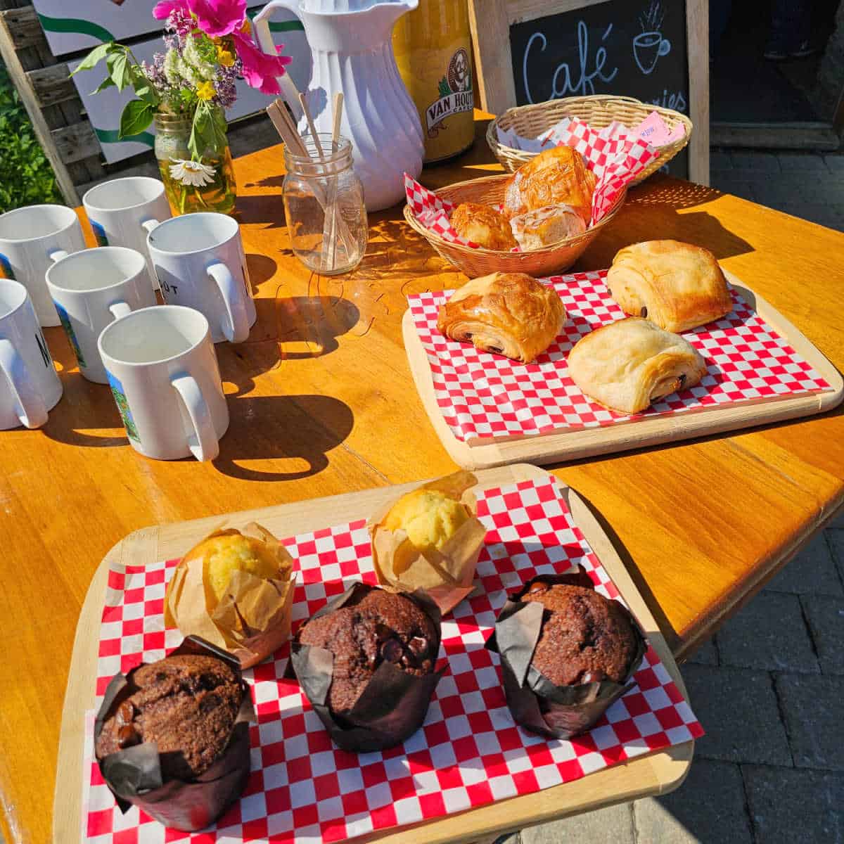 bakery boards with fresh pastries next to white mugs and carafes
