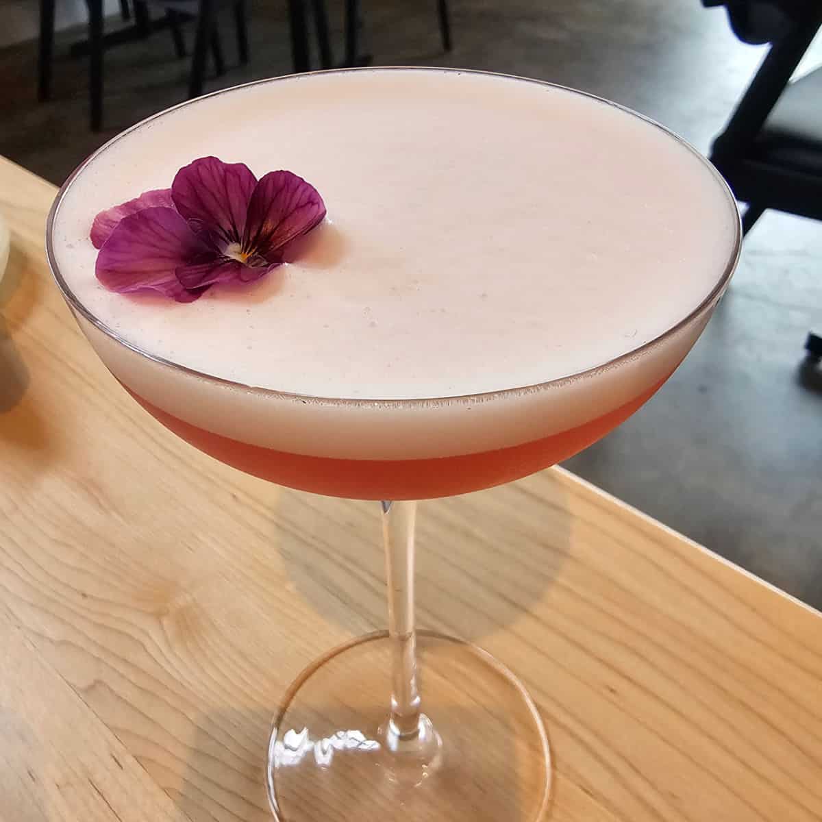 Gorgeous pink cocktail with a flower on top