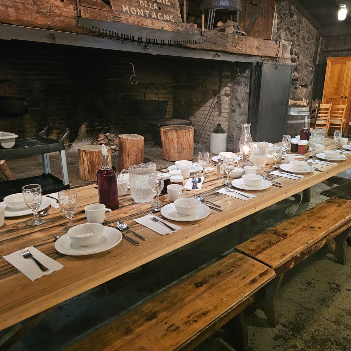 long wooden table with place settings and large bottles of maple syrup