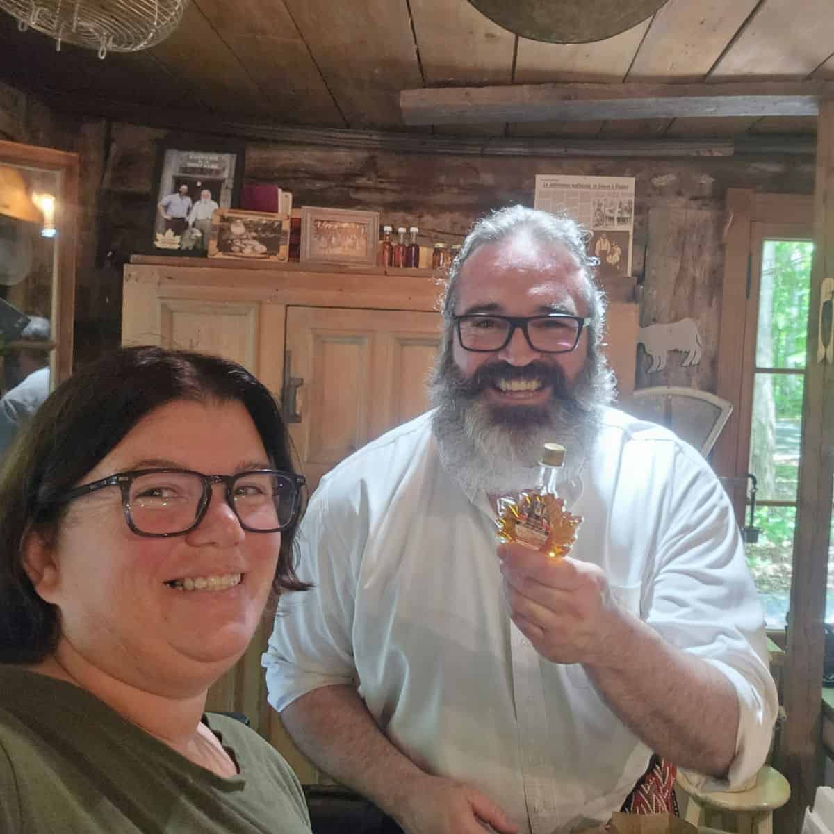 Tammilee and Stefan Faucher holding a bottle of maple syrup