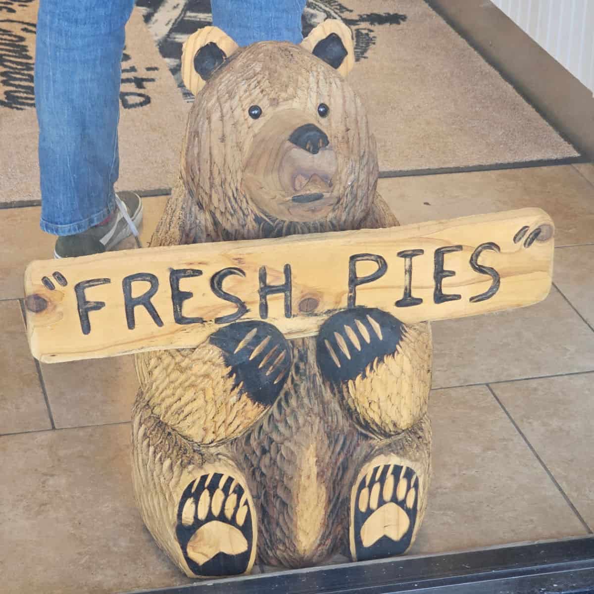 Wooden bear holding a Fresh Pies sign at Yosemite Pie Company