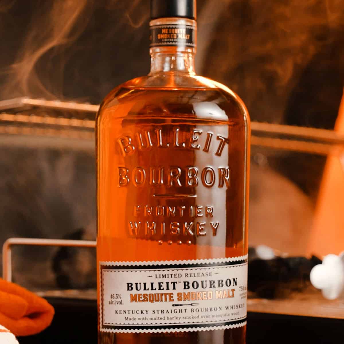 Bulleit Bourbon Mesquite Smoked Malt Whiskey Bottle with smoke around it
