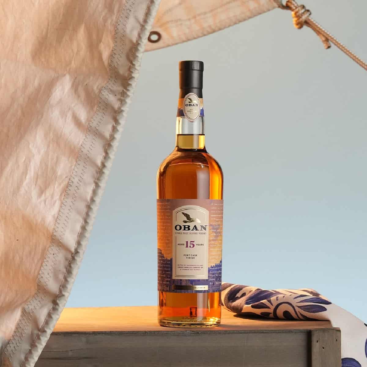 Oban Aged 15 Years Port Cask Finish Single Malt Scotch Whisky bottle next to a sail